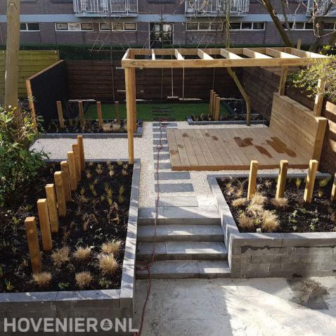 Tuin met bestrating, split en houten vlonder, pergola en schutting 3