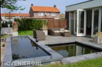 Achtertuin met terras en strakke vijver