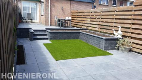 Onderhoudsarme tuin met verhoogd terras, kunstgras en betontegels 1