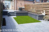 Onderhoudsarme tuin met verhoogd terras, kunstgras en betontegels 1