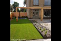 Tuinaanleg met bestrating, gazon, houten pergola en schutting