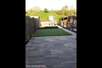 Tuinaanleg met sierbestrating, kunstgras, plantenbak en schutting 1