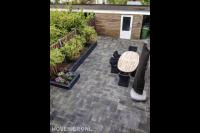 Achtertuin met sierbestrating en plantenbakken 1