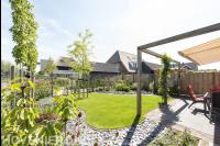Achtertuin met terras, pergola en gazon