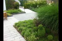 Moderne tuin met lichte bestrating en veel groen 1