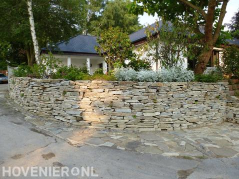 Verhoogde tuin met stenen muur en pad van flagstones
