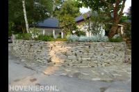 Verhoogde tuin met stenen muur en pad van flagstones