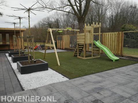 Kindervriendelijke tuin met bestrating, gazon en speeltoestel