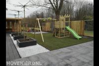 Kindervriendelijke tuin met bestrating, gazon en speeltoestel