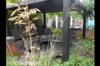 Overkapping van donker hout boven vlonder