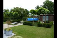Achtertuin met groot gazon en vijver