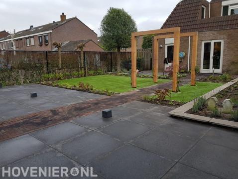 Tuinaanleg met bestrating, kunstgras en houten pergola