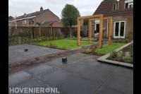 Tuinaanleg met bestrating, kunstgras en houten pergola