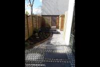 Tuin met schutting, border, plantenbak en bestrating