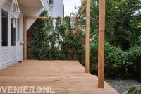 Houten vlonder en pergola met klimop