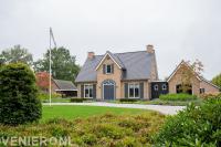 Villatuin met groot gazon en borders met heesters