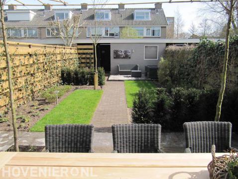 Achtertuin met terras, bestrating, gazon en haagplanten 2