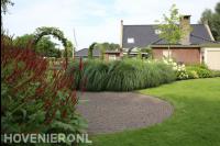 Border met siergras en hortensia's bij gazon
