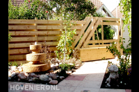Tuin met houten schutting en waterornament