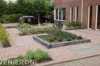 Voortuin met borders en stapstenen in lichtrood grind