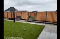 Tuinaanleg met bestrating van siertegels, gazon en houten schutting 1