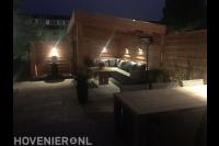 Buitenverlichting op schutting en onder houten overkapping