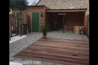 Achtertuin met overkapping, vlonder en natuurstenen tegels