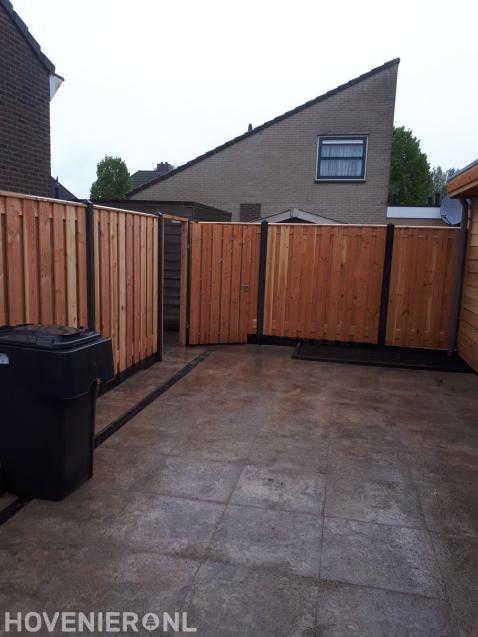 Tuin met sierbestrating en hout beton schutting met poort