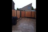 Tuin met sierbestrating en hout beton schutting met poort