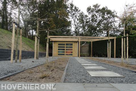 Achtertuin met bestrating, kiezels en tuinhuisje