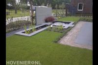 Strakke vijver met stapstenen en watermuur