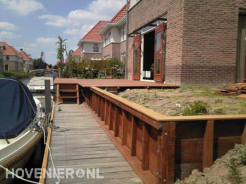 Houten beschoeiing en vlonder in tuin aan het water