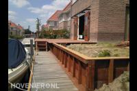 Houten beschoeiing en vlonder in tuin aan het water