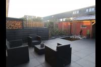 Tuin met vijver, houten overkapping en bestrating van grote tegels 2