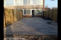 Achtertuin met bestrating, plantenbak en hout beton schutting