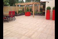 Onderhoudsvriendelijke tuin met houten pergola en rode plantenbakken 1