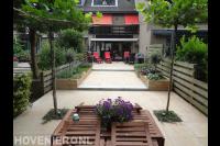 Tuinaanleg lange smalle achtertuin met bestrating en verhoogde borders