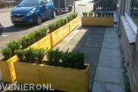 Houten plantenbakken in voortuin