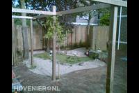 Tuin met houten pergola en schutting