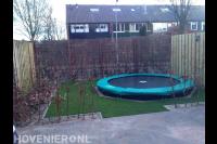 Tuinaanleg met bestrating, kunstgras, trampoline en tuinafscheidingen