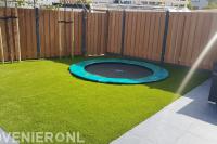 Trampoline omgeven met kunstgras