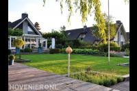 Ruime tuin met terras, gazon en vlonder bij villa