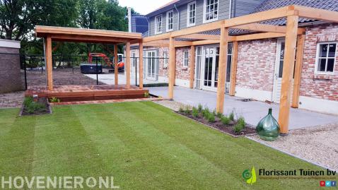 Tuin met gazon van graszoden en houten overkapping, vlonder en pergola