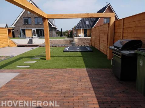 Tuinaanleg met bestrating, kunstgras, houten pergola en schutting 2