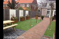 Moderne tuin met kunstgras, cortenstaal plantenbakken en leibomen 1