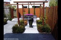 Moderne tuin met houten pergola en schutting