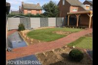 Tuinaanleg met sierbestrating, gazon, schutting en overkapping