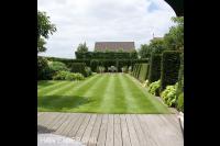 Open tuin met veel groen, groot gazon en vlonder