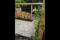 Tuin aan het water met bestrating, pergola, schutting en vlonder