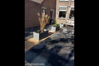 Voortuin met bestrating en plantenbakken op strook van vlonderplanken